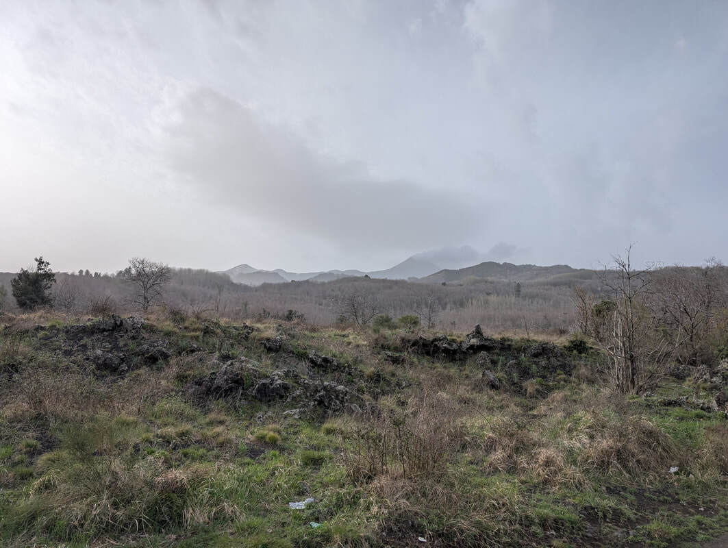 Mount Etna seen from the distance with an ash cloud streaming out.