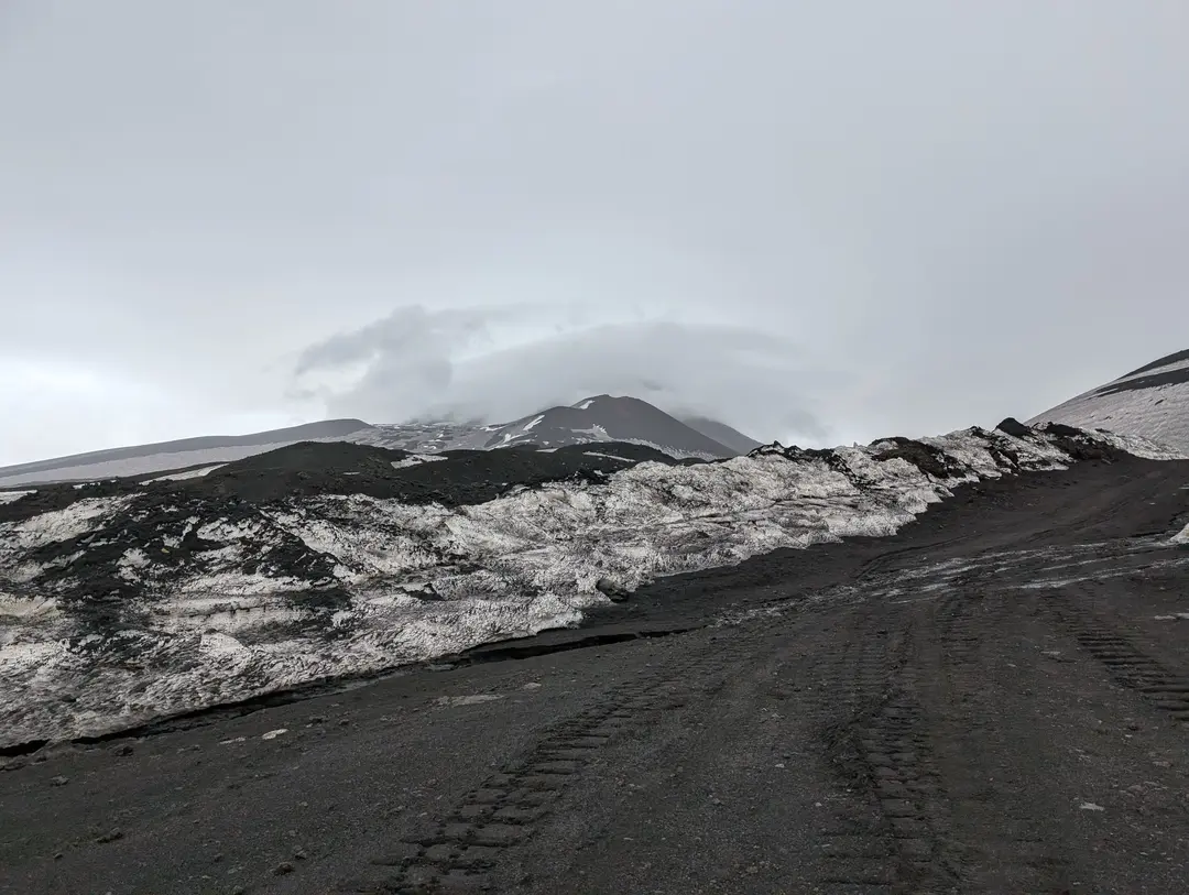 Mount Etna with snow obscured by clouds.