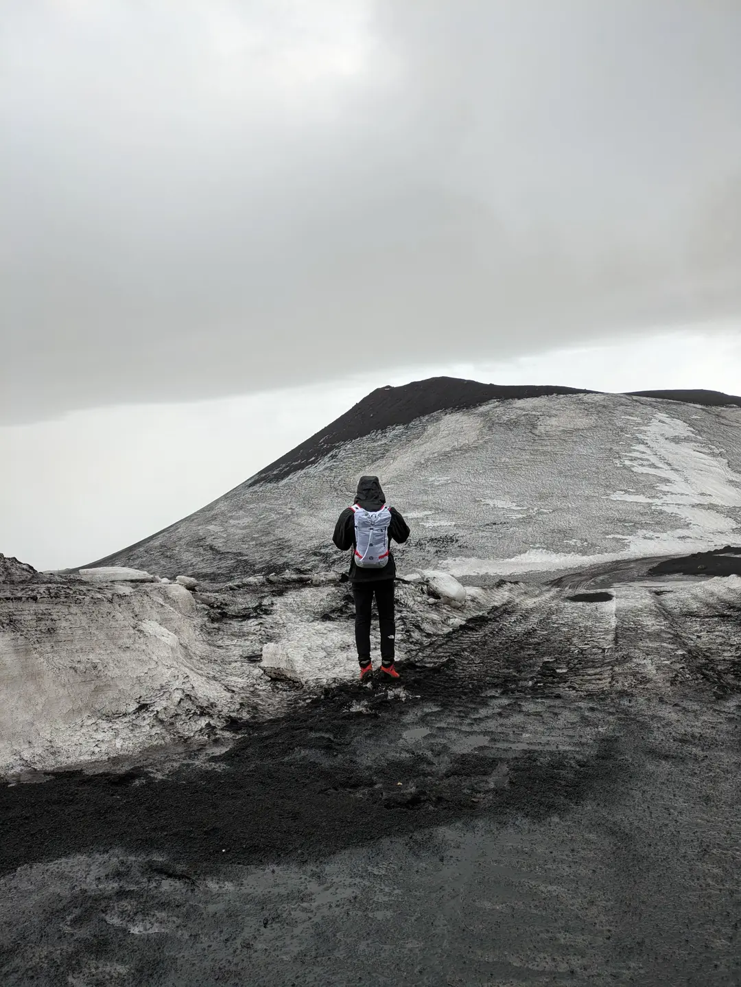 A walker looking out towards an extinct volcanic crater - Montagnola.
