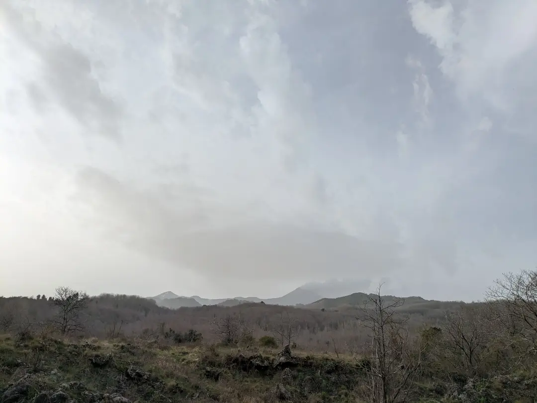 Mount Etna seen from the distance with an ash cloud streaming out.