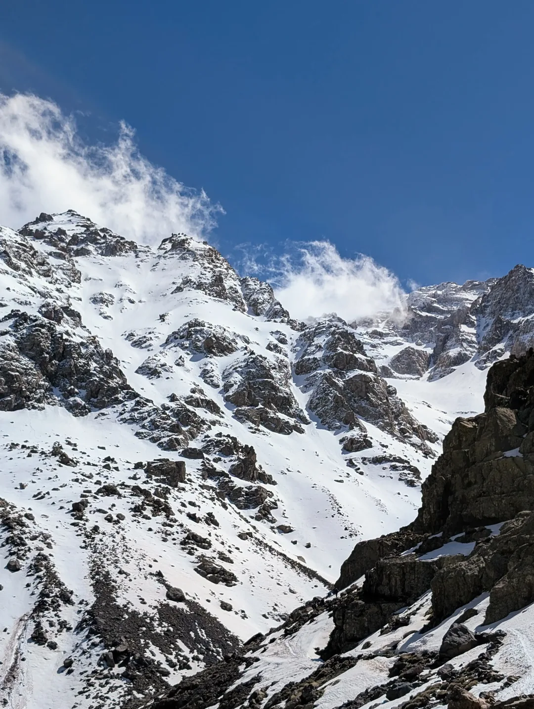 Snow covered mountains with a faint path in the snow